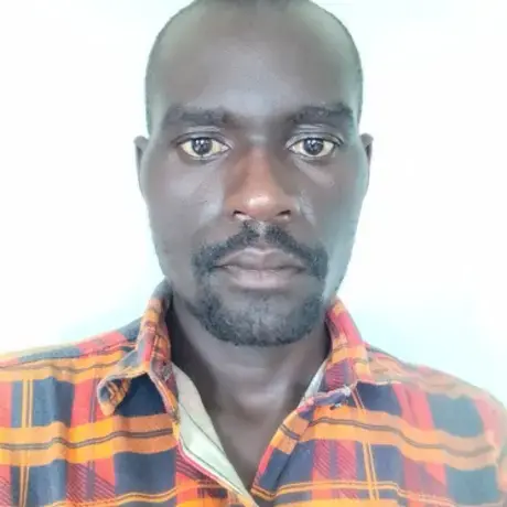 Richard-Drasimaku-1.jpg A man with an orange shirt stares into the camera