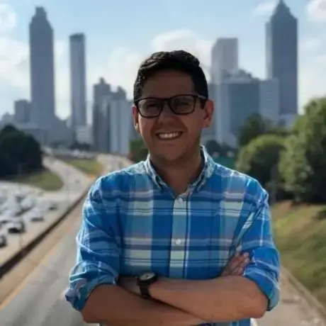 A man with eyeglasses and wears a blue-striped shirt.