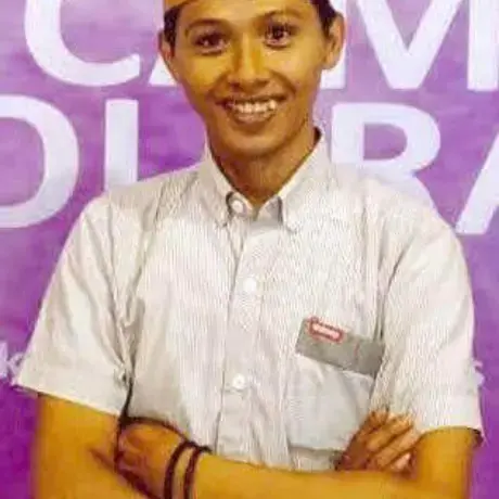 foto-didi.jpg A man wears a grey shirt and an Indonesian, black songkok hat.