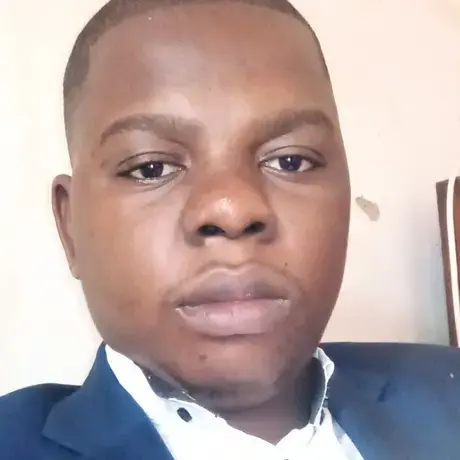 A man with a grey suit, tie, and a white shirt.