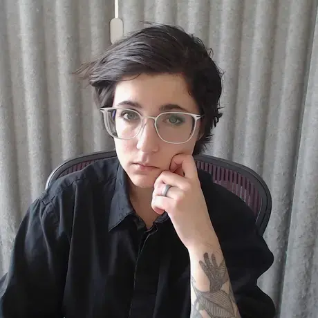 Man in black shirt sits against white backdrop