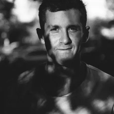 Black and white photo of a man under a tree