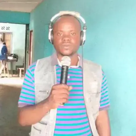 A man wearing headphone is holding a mic.