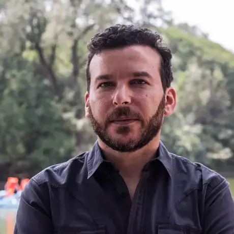 Headshot of a man with short dark hair wearing a navy button down