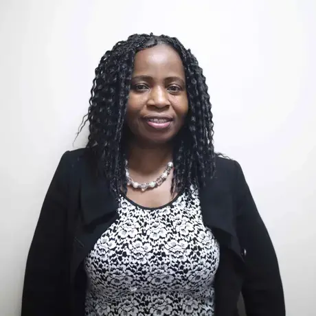 A woman with long hair wearing a black and white top and black blazer