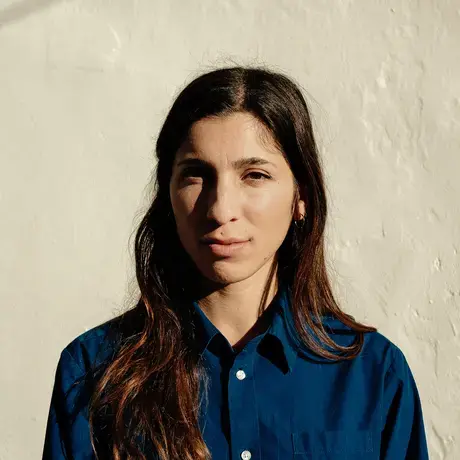 Headshot of a woman with long dark hair wearing a blue collared button-down