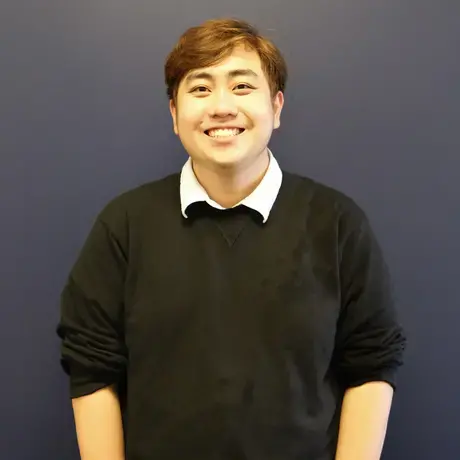 Headshot of Gareth wearing a black sweater against a navy blue background