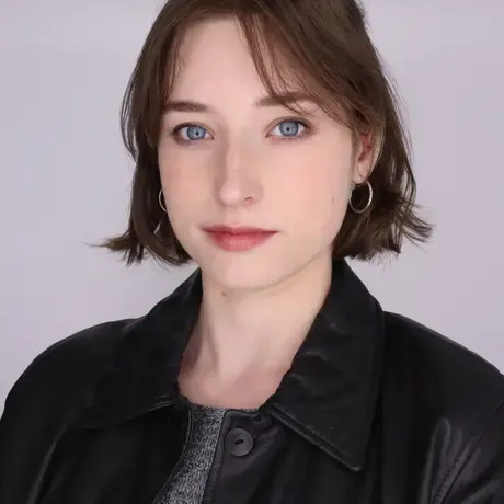 Headshot of Alyson wearing a leather jacket and grey shirt