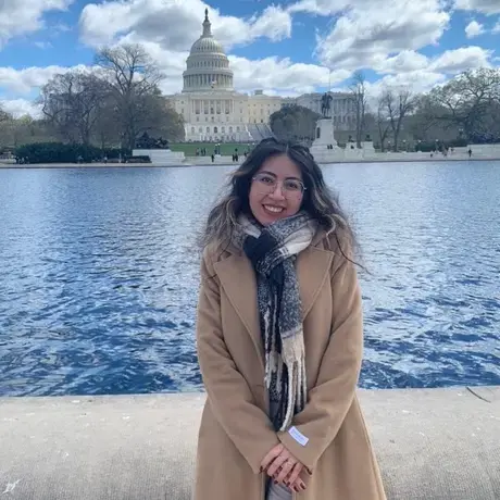 Allison wearing a tan coat in front of the U.S. capitol building
