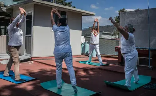 Antonieta Battista Cruz (facing the camera) leads a yoga class as part of a free community programme to combat obesity in Oaxaca. Exercise plans come with advice on healthy diets. Several participants revealed they had been diagnosed with high blood sugar or diabetes and were determined to improve their health for the sake of their families. Image by James Whitlow Delano. Mexico, 2017.