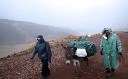 Paul Salopek's guides walk through a wet and cold Uzbek mountain region.