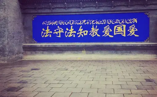 A sign in Ningxia, northwestern China, reads: "Love your country, love your religion; know the law, follow the law." Image by Alice Su. China, 2016. A sign in Ningxia, northwestern China, reads: "Love your country, love your religion; know the law, follow the law". Image by Alice Su. China, 2016.