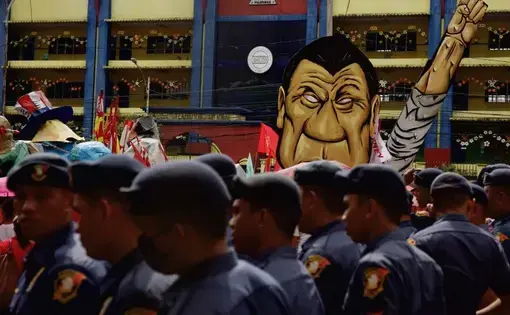 Law enforcement officers in front of an effigy of President Rodrigo Duterte during a rally against the extrajudicial killings and other issues in Quezon City, July 24, 2017. Image by Pat Nabong. Philippines, 2017.