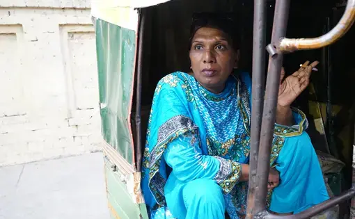 Ashi Jaan, age 45, takes a break from the protest to sit and smoke a cigarette while chatting with the rickshaw driver. Image by Ikra Javed. Pakistan, 2016.