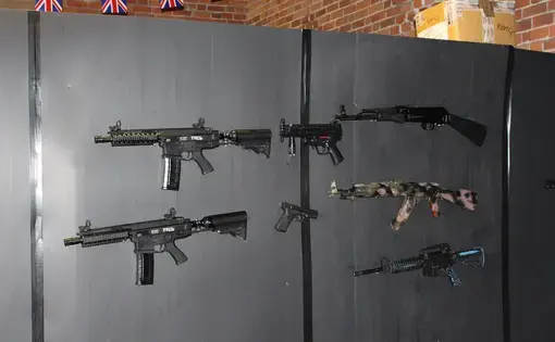 Guns line the wall of a private military company training centre in Hereford. Image by Matt Kennard. England, 2016.
