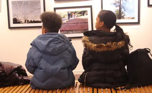 Students look at photographs at the exhibit opening of EverydayDC. Image by Kayla Sharpe. United States, 2018.