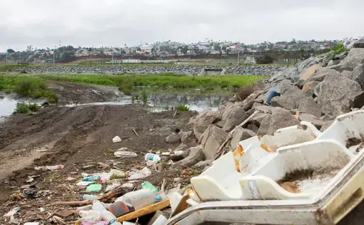 Trash is piled near the U.S.-Mexico border, where sewage from Tijuana flows through. Image by Adriana Heldiz / Voice of San Diego.