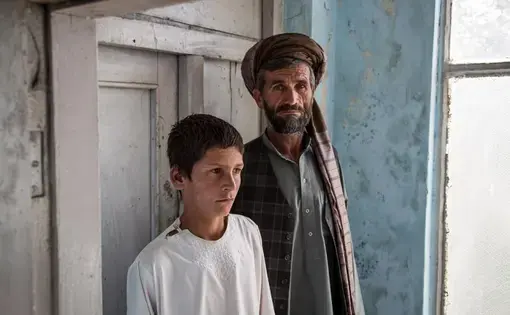 Nawroz and his son Zewarshah at their home in Charkh, Aghanistan, in 2015. Nawroz had sent his sons out to collect grain on the morning of August 3 only to have Zewarshah witness the death of his younger brother, Ayman, whose nickname was Sufi. Image by Jason Motlagh. Afghanistan, 2015. Media file: afghanistan.jpg