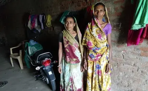 Two women attacked in a witch hunt, Madhuben and Susilaben, stand in an alley ​in Dahod District, Gujarat, India. Image by Seema Yasmin. India, 2017.