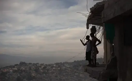 Horlich Florestal (left), 24, and Rosemond Altidon, 22, stand on the edge of their apartment building in Fort National January 9, 2011. Half the building was destroyed in the earthquake, killing many of their neighbors, including two cousins and an aunt. Image Allison Shelley. Haiti, 2011.