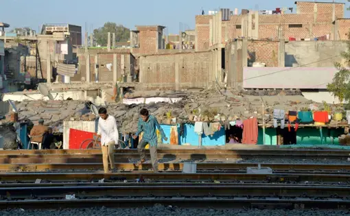 Hassan Khan, 23, and Nawab Khan, 20, both brothers, suffer from cerebral palsy caused by the consumption of contaminated groundwater. Due to their poor health, even basic things like crossing railway lines on the way to their home is a struggle. Image by Rohit Jain. India, 2018.