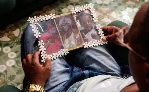 Jorge Álvarez holds a photo of three of four people killed in a 2015 building collapse. From left, his nephew Jorge Álvarez, 18; his mother, Mayra Páez, 60; and his daughter Genolan Álvarez, 3. Jorge’s girlfriend, Yaima Kindelán, 18, also died in the incident. Image by Tracey Eaton. Cuba, 2018.