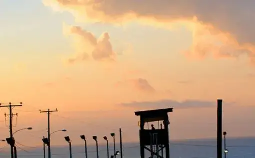 A watchtower at the Guantanamo Bay prison camp, at dusk. Image courtesy of Wikimedia Commons. Cuba, 2011.