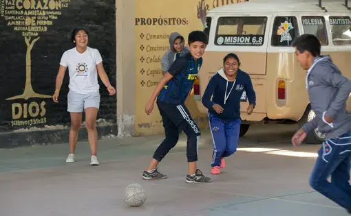 Young people play soccer at Villa Galindo Baptist Church in Cochabamba. Some children go to the church on weekends while their parents work. Others come from San Sebastian prison, which is overcrowded and has no playground. "Soccer, jumping around, it's part of letting off steam," Pastor Alex Villarroel said. Image by Tracey Eaton. Bolivia, 2017.