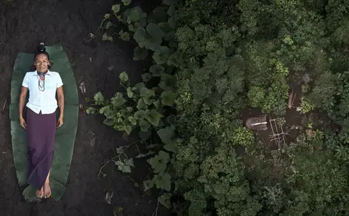Verónica is an Achuar woman who works as a midwife for a community in which, according to her, women are ashamed of giving birth. At the left, Verónica lies on the ground. At the right is a garden of medicinal plants, from which she cultivates traditional remedies to treat her patients. Image by Pablo Albarenga. Ecuador, 2019.