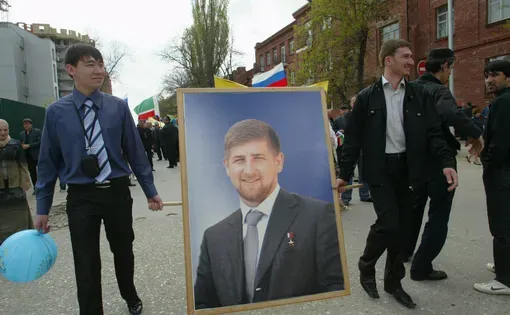 Young men carry a portrait of Ramzan Kadyrov, head of Chechnya, during May 9 Victory Day celebrations in Chechnya. Image by Musa Sadulayev. Russia, 2009.
