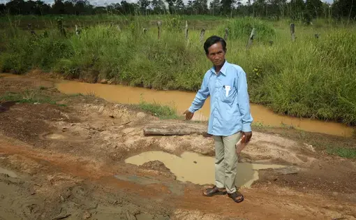 Journalist Coy Saveuth shows the spot where environmental journalist Taing Try's body was found
