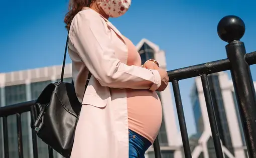 A pregnant woman walks down the street in London. Image by Corpii / Shutterstock. United Kingdom, undated.