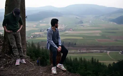 Rafat Al Aydi, 20, right, takes in the view of southwestern Germany with his brother Naif, 16, during a walk in the Black Forest near their home in tiny Zell am Hammersbach, Germany in March 2014. The four Al Aydi boys, unable yet to speak German, struggled to adjust to life in their new village, but it wasn’t long before their family was on the move again, searching for a real place to call home. Image by Holly Pickett. Germany, 2014. Media file: pc_germany_med_008.jpg