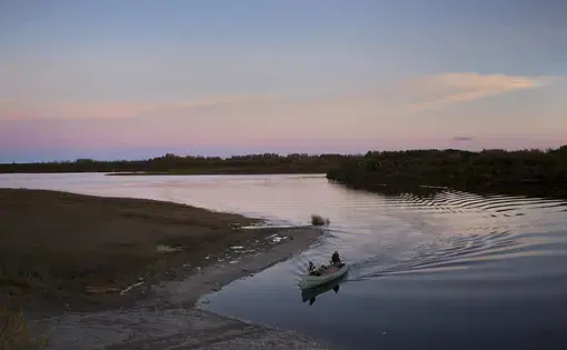 Attawapiskat, Ontario, Canada. A family returns by canoe from cutting firewood in preparation for the cold, long winter ahead. Image by David Maurice Smith. Canada, 2016.