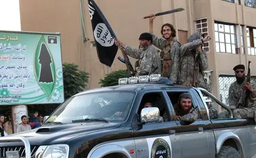 ISIL fighters parade through Raqqa, Syria, in a caravan of Toyota pickup trucks, 2014