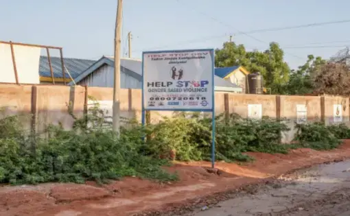 A sign advertising a hotline for people to call and report gender based violence related crimes in Wajir, Kenya. Image by Peter DiCampo. 2018.