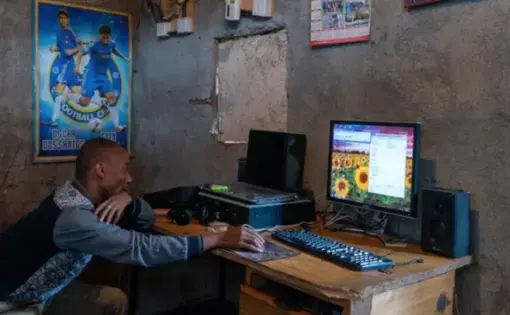 Caleb Yongo, a resident of the Gatwekera neighborhood in Kibera, Nairobi. Caleb runs a business from his house doing printing, photocopying, and typing. He uses an illegal power connection as that is the only power available for him. Image by Peter DiCampo. Kenya, 2018.