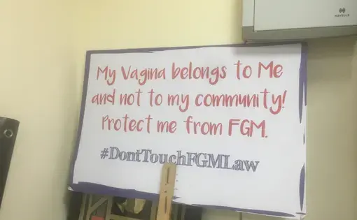 A sign held at Equality Now office in Nairobi urges people to not interfere with the 2011 Prohibition of Female Genital Mutilation law. Image by Merdie Nzanga. Kenya, 2018.