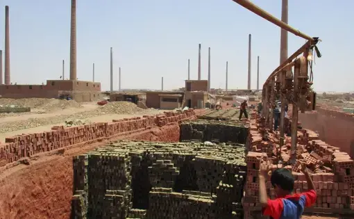 Laborers south of Cairo manufacture bricks to feed Egypt's construction industry. With currency pressures on commodities and real estate, this is one of a handful operating hundreds of factories. Image by Jahd Khalil. Egypt, 2016.