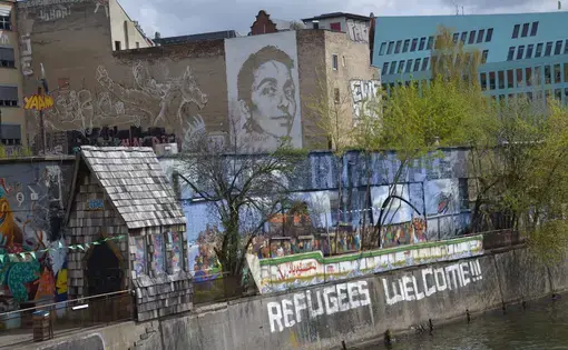 A mural in Berlin says "Refugees Welcome." Image by Jeanne Menjoulet. Berlin, 2016.