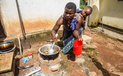 Flora Kandodo of Nessa village near Mulanje, Malawi, is cooking relish on her new Aleva stove—an improved cook stove that is fuel efficient and smokes less. Image by Nathalie Bertrams. Malawi, 2017.