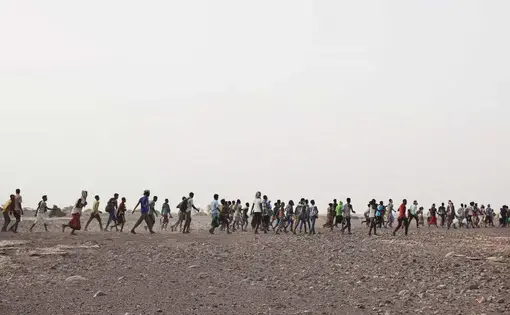 Ethiopian migrants are led by smugglers in Obock, Djibouti, July 14, 2019, prior to crossing the Bab el-Mandeb strait to Yemen. Image by AP Photo / Nariman El-Mofty. Djibouti, 2019.
