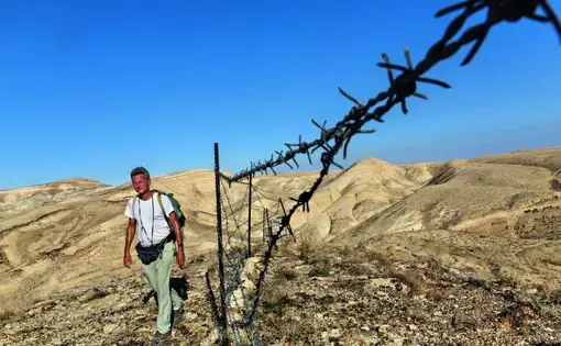 Striding toward Bethlehem, in the West Bank, Salopek is detoured by a herder’s tattered fence, one of the first human-made barriers—other than checkpoints and border gates—he’s faced in some 2,300 miles since he started out in Ethiopia. Image by John Stanmeyer/National Geographic.