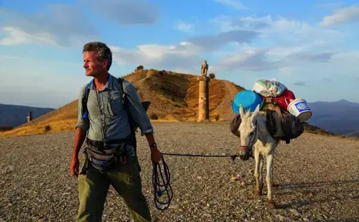 In eastern Turkey, Paul Salopek leads his mule past the Karakuş royal tomb, built in the first century B.C. by one of the area’s many ruling states. When Syrians began to pour over the border 70 miles to the south, he and photographer John Stanmeyer drove down separately to report on the situation. Image by by John Stanmeyer/National Geographic.