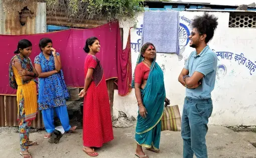 Suraj Yengde in his neighborhood, encouraging Dalit women to try to continue their education, in spite of institutional barriers. Image by Phillip Martin/WGBH News. India, 2019.