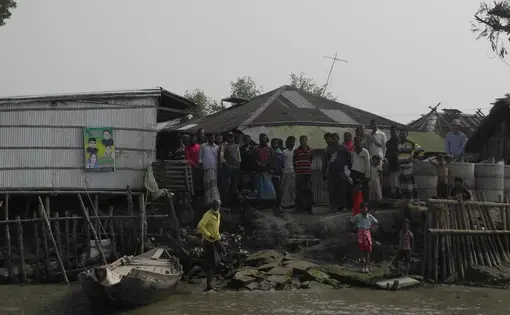 Residents stand at the edge of Polder 32 on the Bangladesh coast. The polder was inundated by Cyclone Aila in 2009. The flooding lasted two years, after the walls surrounding the polder were damaged. Now the walls are being rebuilt. But some scientists warn that's inviting another disaster. Residents of Polder 32 on the Bangladesh coast.