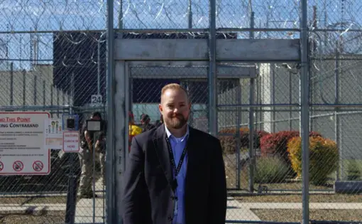 Idaho Department of Correction Director Josh Tewalt stands in front of the Idaho State Correctional Center. Image by Madelyn Beck / Boise State Public Radio. United States, 2020.