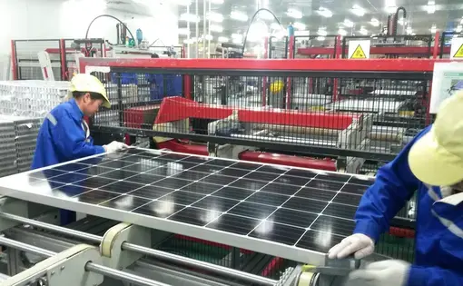 Workers assemble a solar panel at Jinko Solar’s factory in Haining, Zhejiang province. China is in the midst of the world’s biggest-ever investment in renewable power, seeking to reduce its reliance on coal and ease air pollution that is estimated to kill more than a million people in the country every year. Image by Beth Gardiner. China, 2017. Workers assemble a solar panel inside of a factory in Haining, Zhejiang province, China.