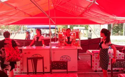 Servers at a snack counter in a tent located outside a cinema in Pyongyang during the Pyongyang International Film Festival. Image by Laya Maheshwari. North Korea, 2016.