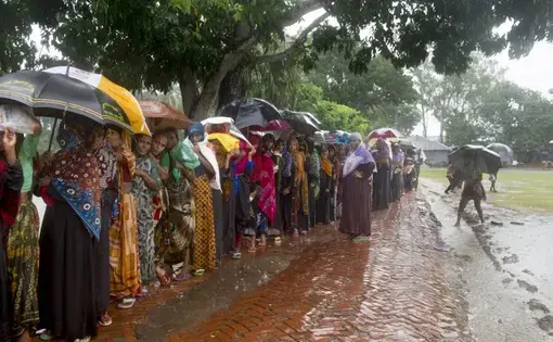 Women wait in line in the rain to collect 20kg bags of rice that is given out by the government as part of a VGF (Vulnerable Group Feeding) program ahead of Eid-ul-fitr in a southwestern village of the country. Image by Nikita Sampath. Bangladesh, 2016.